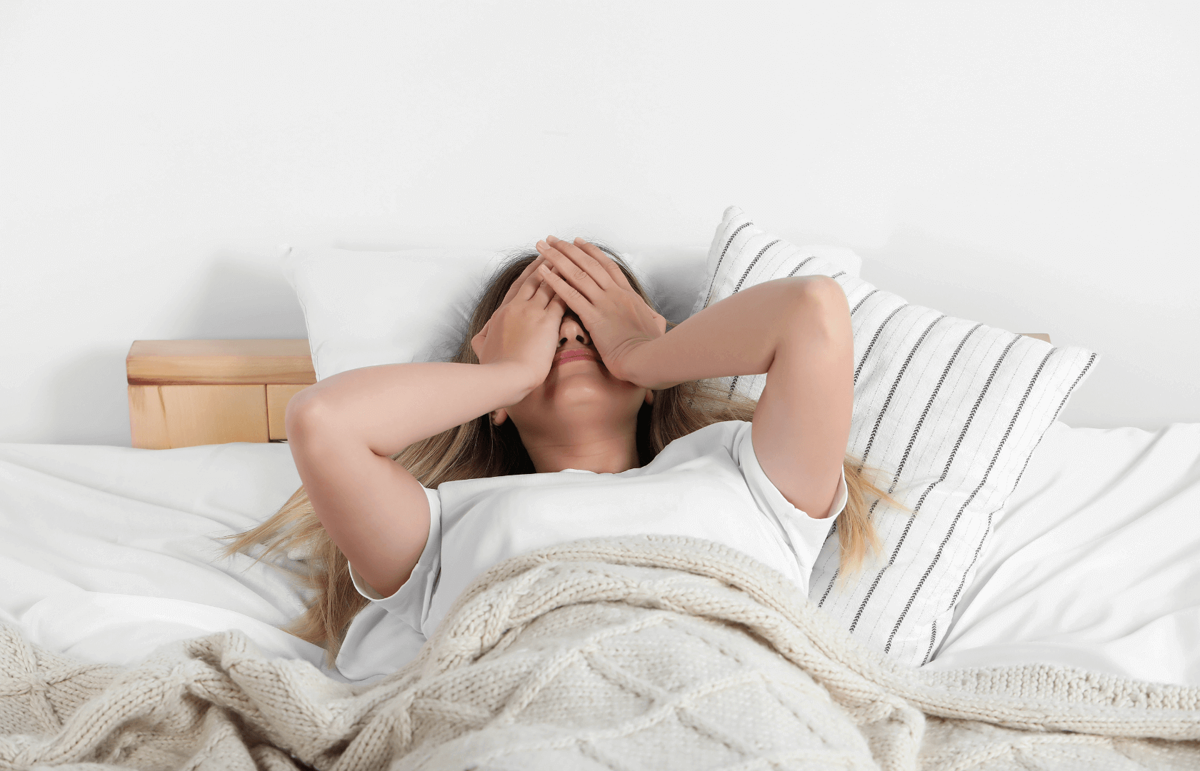 Vrouw ligt in bed en heeft last van slaapstuipen.